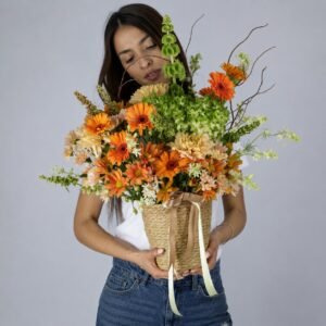 Soleil d'Or — composition gerberas orange, chrysanthèmes ambre et Bells of Ireland en panier paille, Flower Expert Maroc